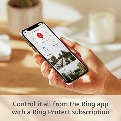 Hand holding a smartphone displaying the Ring app with Ring Protect subscription.