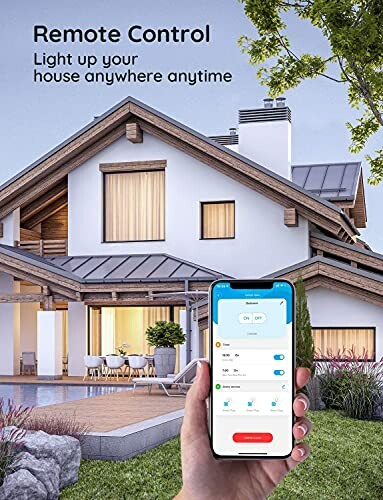 Hand holding smartphone with home lighting control app in front of modern house.